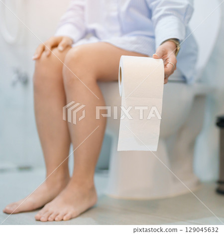 Woman holding toilet paper roll while sitting on toilet bowl. digestion, constipation, Diarrhea from food poisoning, infection, abdominal, stomachache, cystitis, Insurance, Health care and Medical 129045632