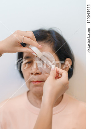 Senior Woman during eye protecting by shield after eye surgery. Eye disease, Cataract,  Glaucoma, Age Related Macular Degeneration, Diabetic Retinopathy, Vitreous, Lasik, World Glaucoma day and health 129045653