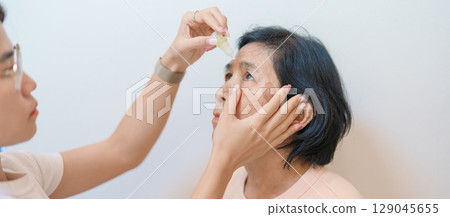 Elderly Woman use ophthalmic solutions or Eye Drops after eye surgery. Eye disease, Cataract,  Glaucoma, Age Related Macular Degeneration, Diabetic Retinopathy, World Glaucoma day and health treatment 129045655