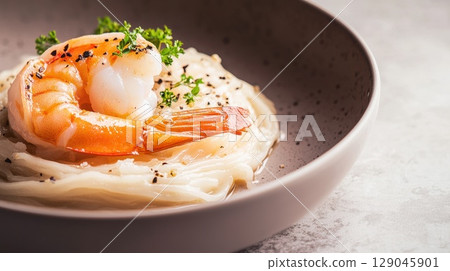Delicious shrimp and rice noodles served in a bowl with delicate broth Delicious shrimp and rice noodles served in a bowl with delicate broth 129045901