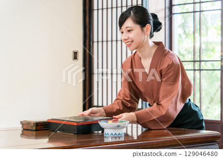 A waitress serving food to the guest rooms of an inn, a ryokan staff member A waitress serving food to the guest rooms of an inn, a ryokan staff member 129046480