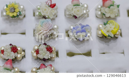 Exhibition and sale of colorful and delicate rings with floral details 129046613