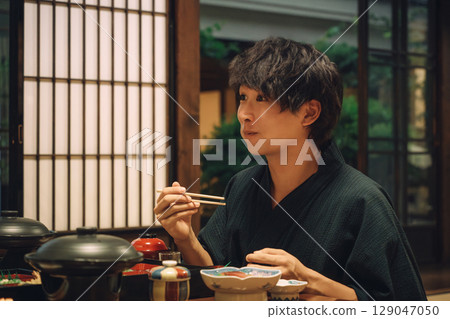 A man in a yukata eating dinner at a hot spring inn, in-room dining, or in a traditional Japanese inn 129047050