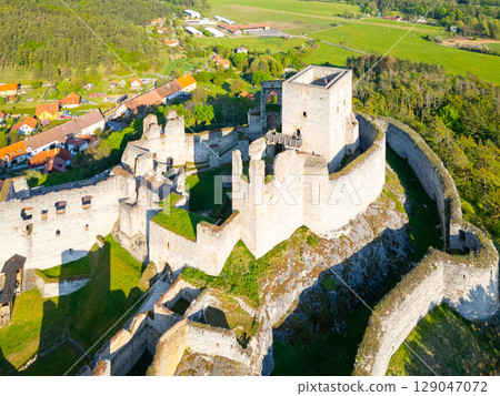 An aerial view captures the ancient ruins of Rabi Castle, showcasing its impressive stone walls and surrounding landscape in Czechia. The castle sits atop a hill, surrounded by lush greenery. An aerial view captures the ancient ruins of Rabi Castle, showcasing its impressive stone walls and surrounding landscape in Czechia. The castle sits atop a hill, surrounded by lush greenery. 129047072