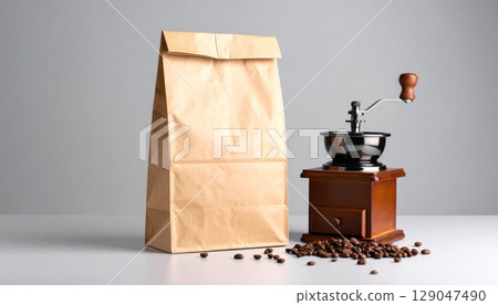 Vintage wooden coffee grinder with roasted brown beans and kraft paper bag 129047490