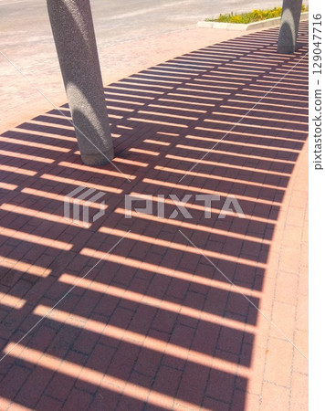 A park scene with the shade of an empty sunshade terrace on a hot day A park scene with the shade of an empty sunshade terrace on a hot day 129047716