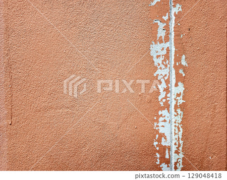 Weathered Concrete Wall Featuring Brown Peeling Paint and Visible Cracks. 129048418