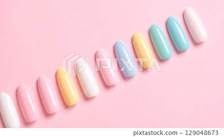 Colorful and cute nail tips arranged diagonally on a pink background 129048673