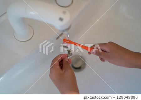 A child brushing orthodontic appliances (expansion plates) with a toothbrush A child brushing orthodontic appliances (expansion plates) with a toothbrush 129049896