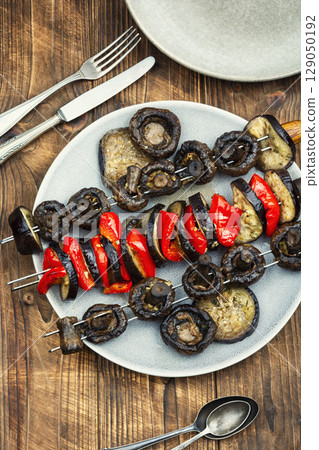 Grilled skewers with various vegetables on wooden rustic background. 129050192