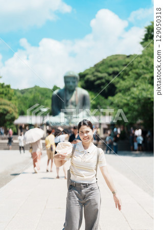Woman tourist Visiting in Kamakura, Kanagawa prefecture , Japan. happy Traveler sightseeing the Great Buddha statue. Landmark and popular for tourists attraction near Tokyo. Travel and Vacation 129050318