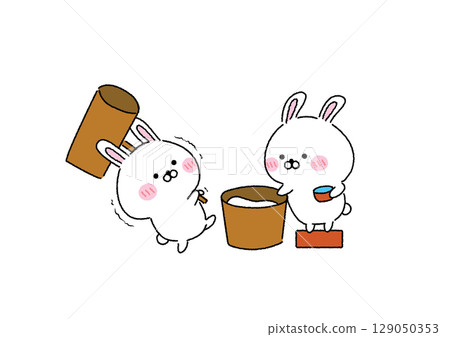 A cute and relaxed rabbit pounding mochi 129050353