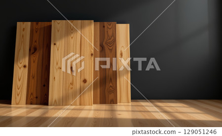 Wooden plank board with natural grain pattern leaning on dark wall with sunlight casting shadows on wooden floor Wooden plank board with natural grain pattern leaning on dark wall with sunlight casting shadows on wooden floor 129051246