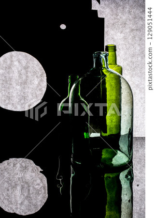 Still life with colored bottles with reflection on a dark background Still life with colored bottles with reflection on a dark background 129051444