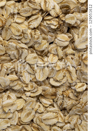 a large number of flakes from pressed oat grains, ingredients for cooking porridge 129051612