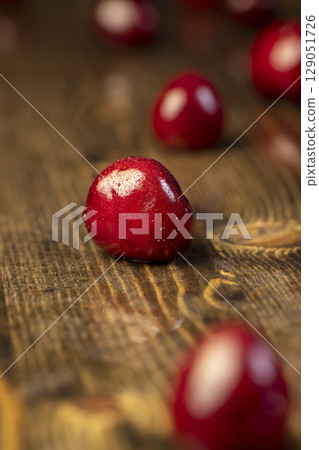 wet cherry berries in drops of water, wet red cherry fruits on the kitchen table wet cherry berries in drops of water, wet red cherry fruits on the kitchen table 129051726