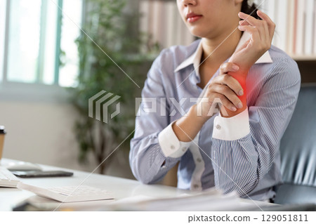 Office Syndrome: Woman Holding Her Wrist in Pain While Working 129051811
