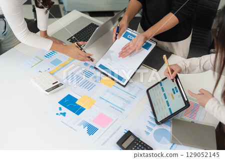 Co working team meeting concept: Businessman working and studying together with tablet document graph paper in office, discuss finance and marketing reporting file in working place. 129052145