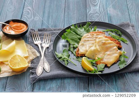 grilled chicken breast topped with melted cheese 129052209