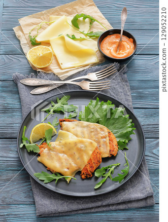 grilled chicken breast topped with melted cheese 129052210