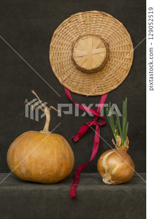 Still life with pumpkin, hat and sprouted onions Still life with pumpkin, hat and sprouted onions 129052519
