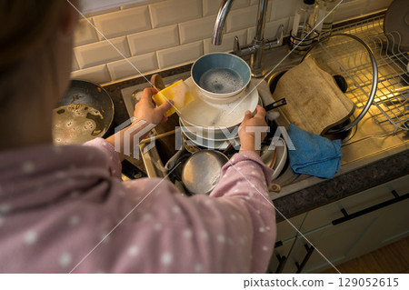 Female hands washing dishes in kitchen, clean space - clean mind 129052615