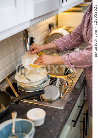Female hands washing dishes in kitchen, the mindful chore 129052625