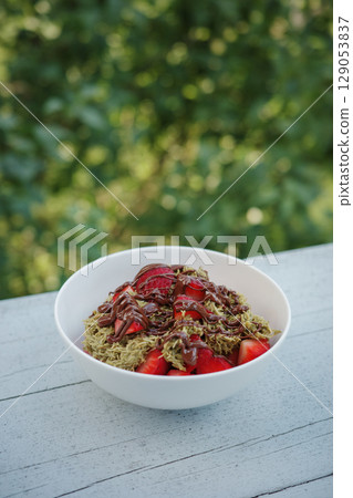 Homemade Dubai chocolate strawberry cup dessert with kataifi, pistachio paste, milk chocolate and fresh strawberries. Top view, vertical photo. Street food desserts and sweets. Copy space for text. 129053837