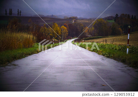A landscape of a road in late autumn in Biei, Hokkaido, with a light rain falling A landscape of a road in late autumn in Biei, Hokkaido, with a light rain falling 129053912