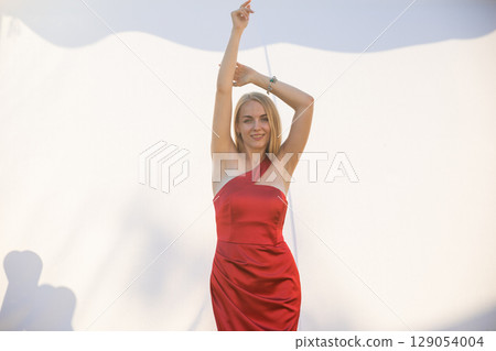Beautiful woman in red dress smiling on white background Beautiful woman in red dress smiling on white background 129054004