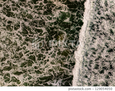 Top view beach with waves crashing on sandy shore Beautiful waves sea surface in summer seascape background Top view beach with waves crashing on sandy shore Beautiful waves sea surface in summer seascape background 129054050