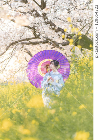 黃昏時分，一位中年婦人撐著日本傘走在盛開的櫻花下 129054222