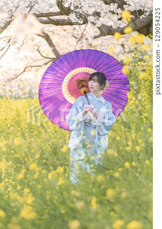 黃昏時分,一位中年婦人撐著日本傘走在盛開的櫻花下 黃昏時分,一位中年婦人撐著日本傘走在盛開的櫻花下 129054225