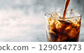 A high-definition close-up of the moment when iced coffee is poured into a glass of ice. 129054773