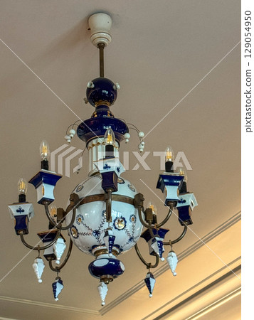 Elegant antique chandelier with blue accents in a vintage interior Elegant antique chandelier with blue accents in a vintage interior 129054950