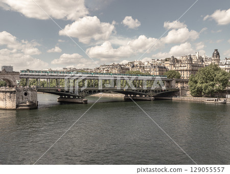 Scenery view of A metro train crossing the Pont de Bir Hakeim bridge with sky in the background over the Seine river in Paris. Scenery view of A metro train crossing the Pont de Bir Hakeim bridge with sky in the background over the Seine river in Paris. 129055557