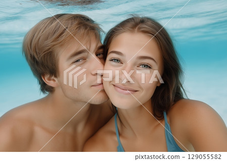 A serene underwater scene featuring a man and a woman with gentle expressions 129055582