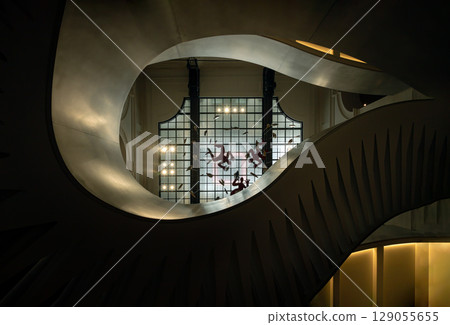 Looking up of The grand helical staircase featuring graceful curves and intricate design with glass ceiling in the background. Looking up of The grand helical staircase featuring graceful curves and intricate design with glass ceiling in the background. 129055655