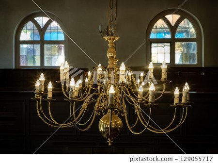 Stunning view of Chandelier hanging from the ceiling with two glass windows in the background. Stunning view of Chandelier hanging from the ceiling with two glass windows in the background. 129055717