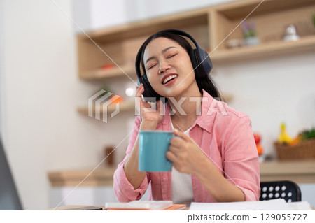 Work from Home: Woman enjoying music while sipping coffee Work from Home: Woman enjoying music while sipping coffee 129055727