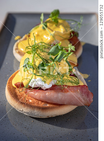 Eggs Benedict made with english muffin, grilled bacon, a brace of poached hen's eggs & hollandaise sauce and watercress. 129055732