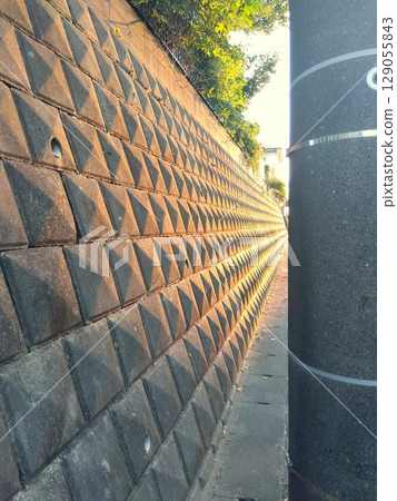 夏日午後的陽光照射在斜坡上的擋土牆 129055843