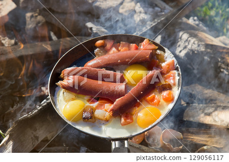 scrambled egg fried on coals in a pan on fire 129056117