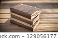 Stack of Premium Dark Chocolate Bars with Milk Chocolate Layers on Wooden Background 129056177