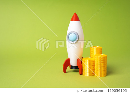 Rocket and coins. Idea for a profitable business, fundraising for starting a business. Startup acceleration, innovation funding. Venture capital investment, entrepreneurial ambition. 129056193