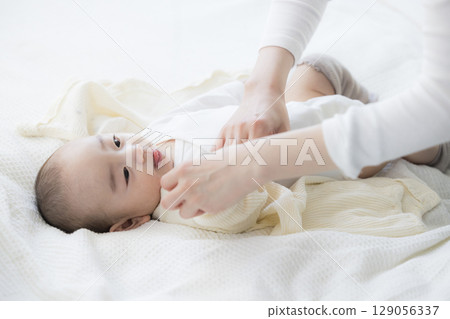 Baby lying on bed 129056337