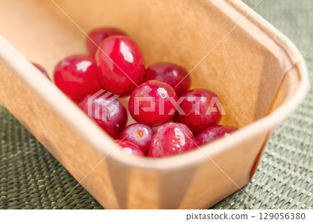 Red ripe grapes in recycled grocery cardboard packaging 129056380