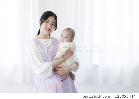 Baby lying on bed 129056414