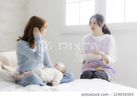 A young mother consulting a public health nurse 129056565