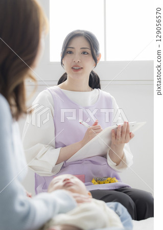 一位年輕的母親諮詢公共衛生護士 129056570